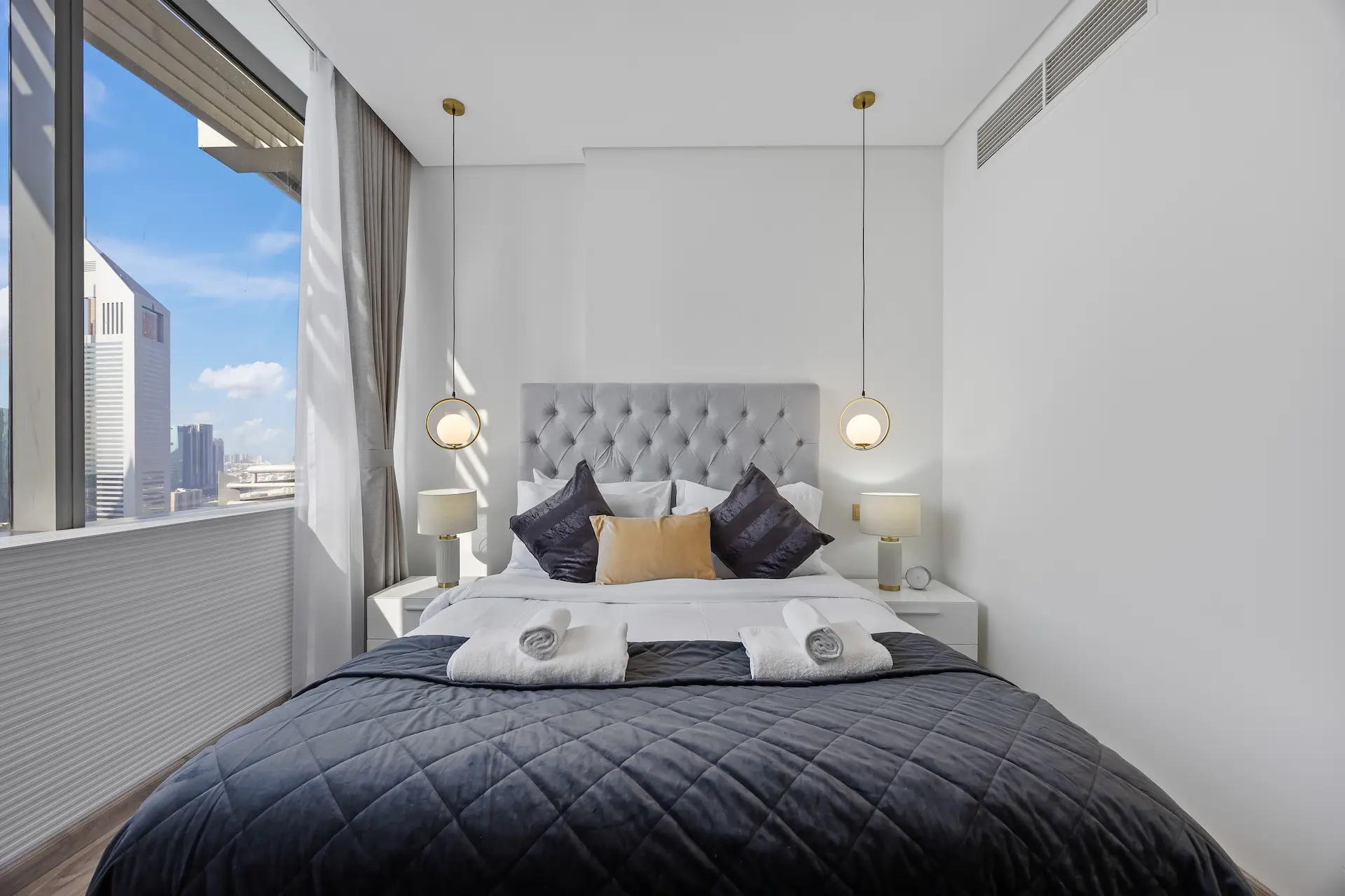 King bedroom with city views and pendant lights at Sky Gardens DIFC Dubai
