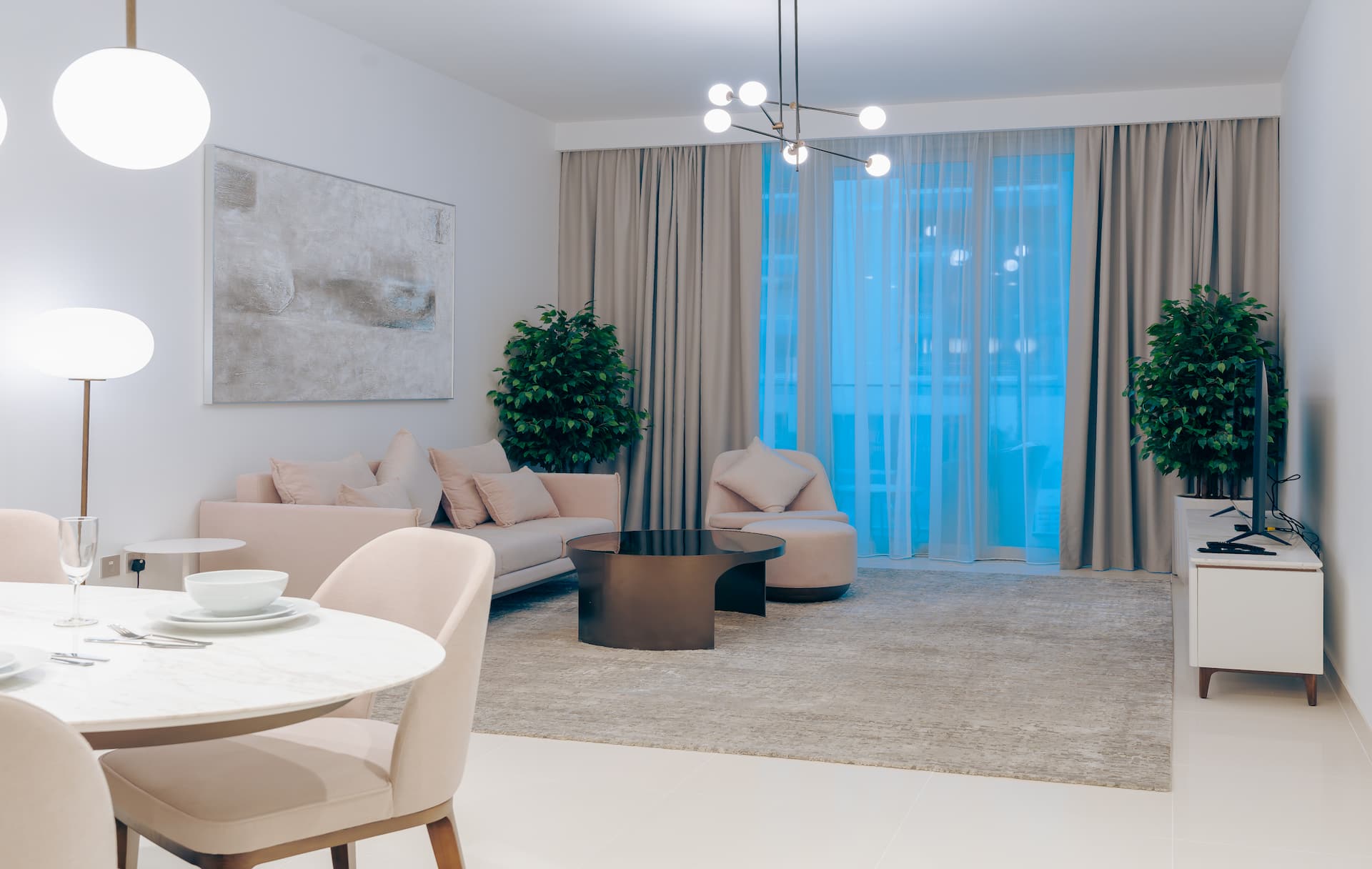 Stylish living and dining space with statement chandelier and balcony access in luxury one bedroom apartment Beach Isle Tower Two