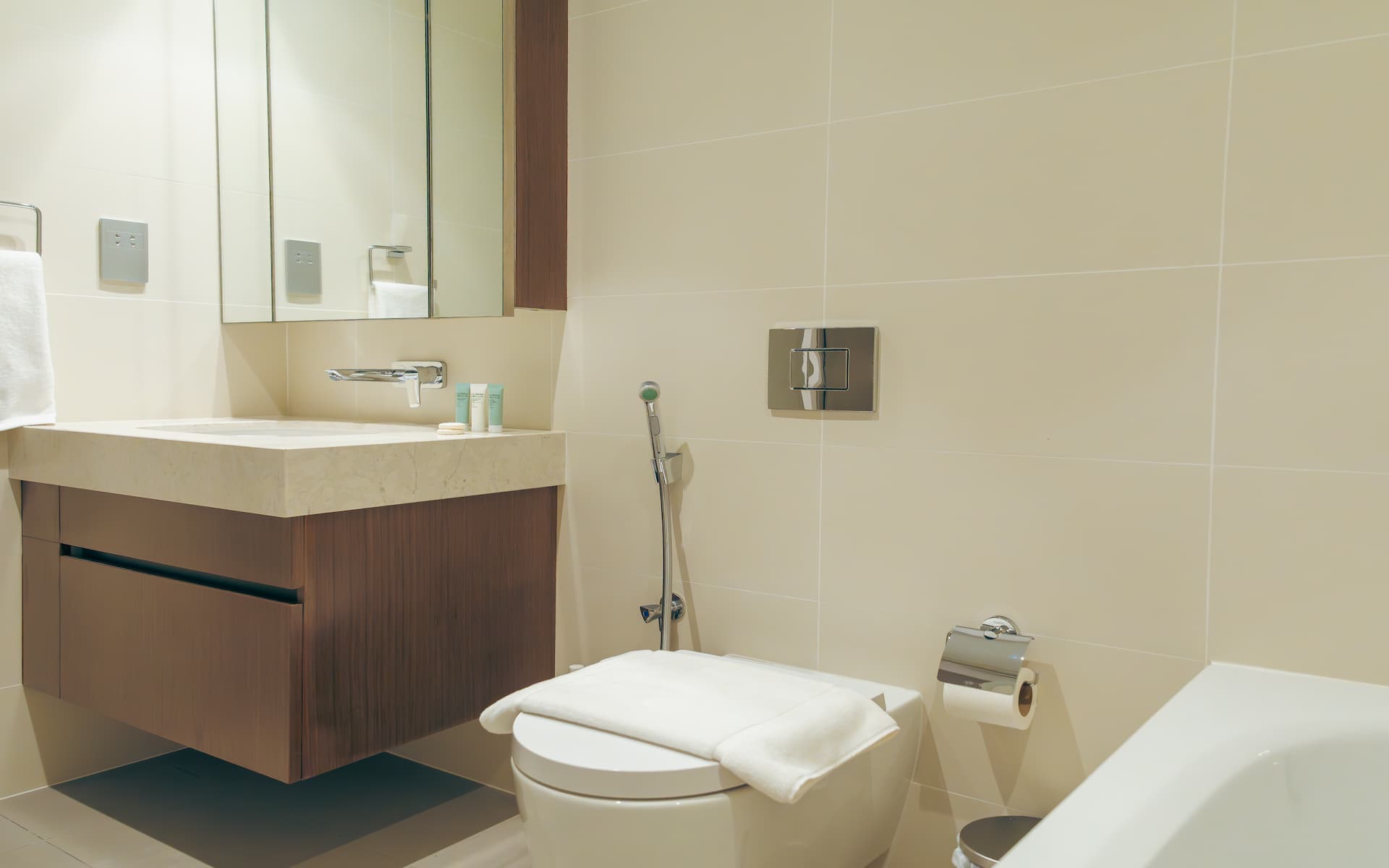 Bathroom with walnut vanity and soaking bathtub in premium one bedroom apartment Beach Isle Tower Two Dubai