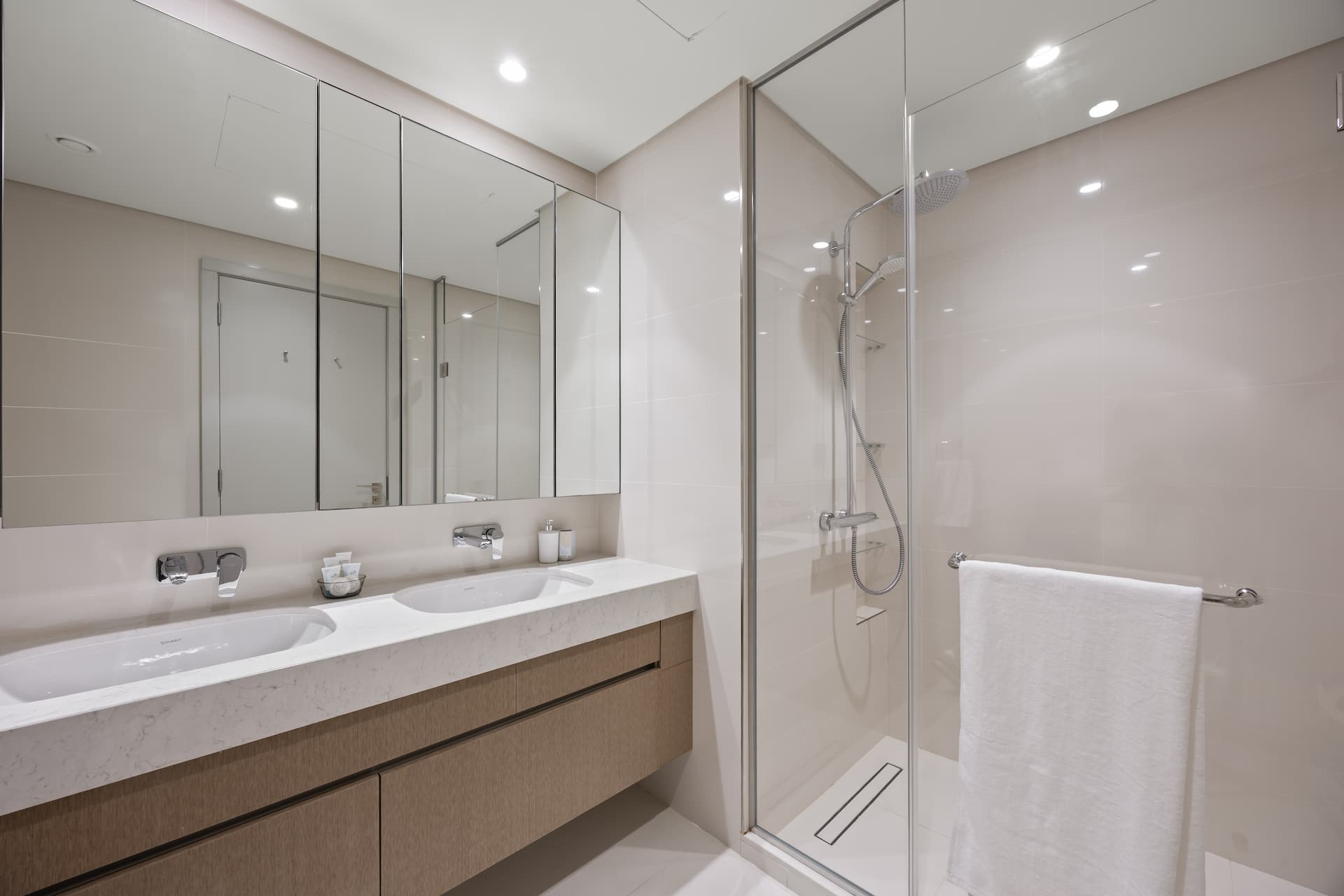 Master ensuite bathroom with double vanity and walk-in rain shower in luxury beachfront apartment Dubai — YOUR STAY Apartments