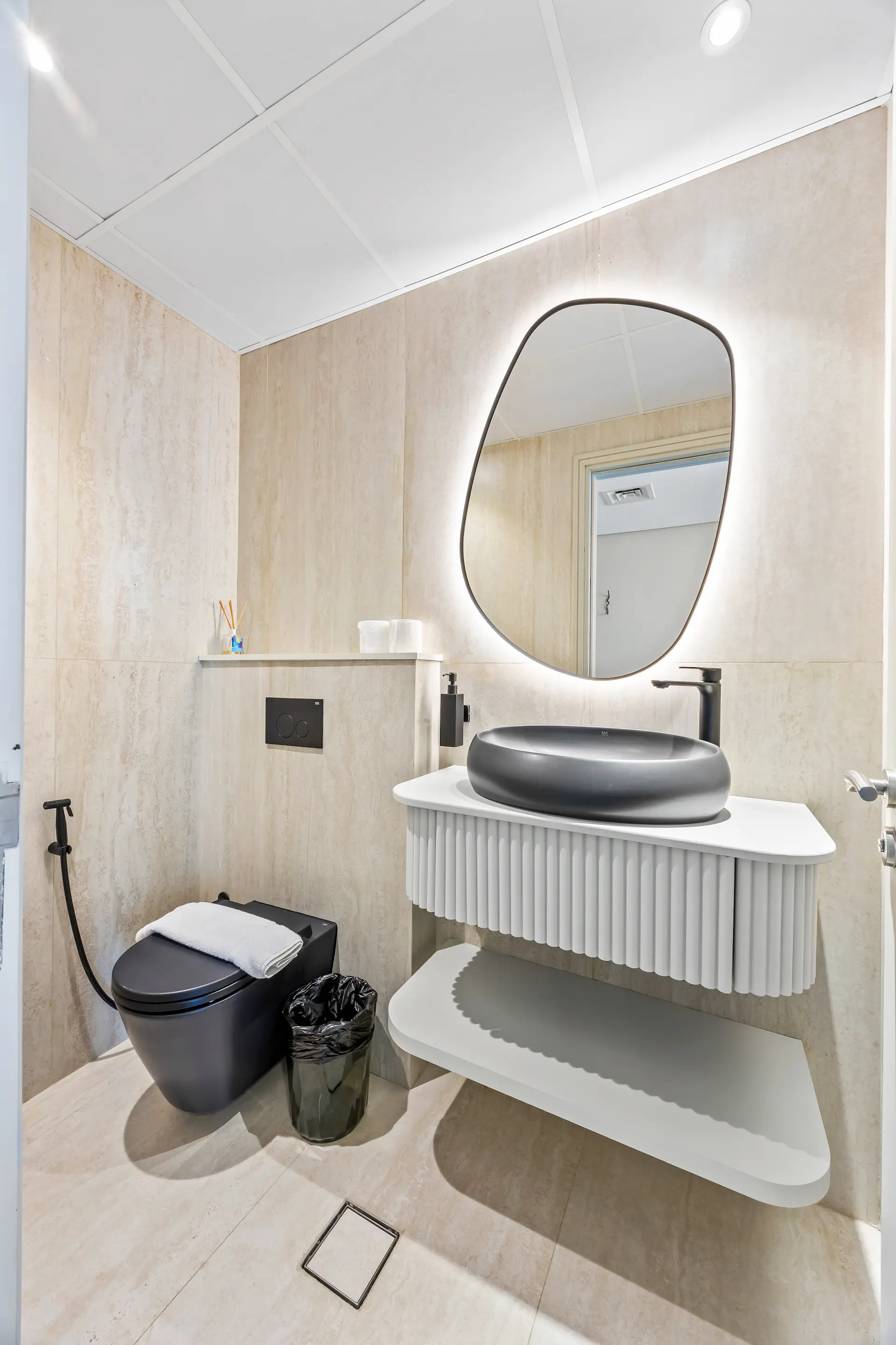 Powder room with vessel basin and backlit mirror at Sky Gardens DIFC Dubai