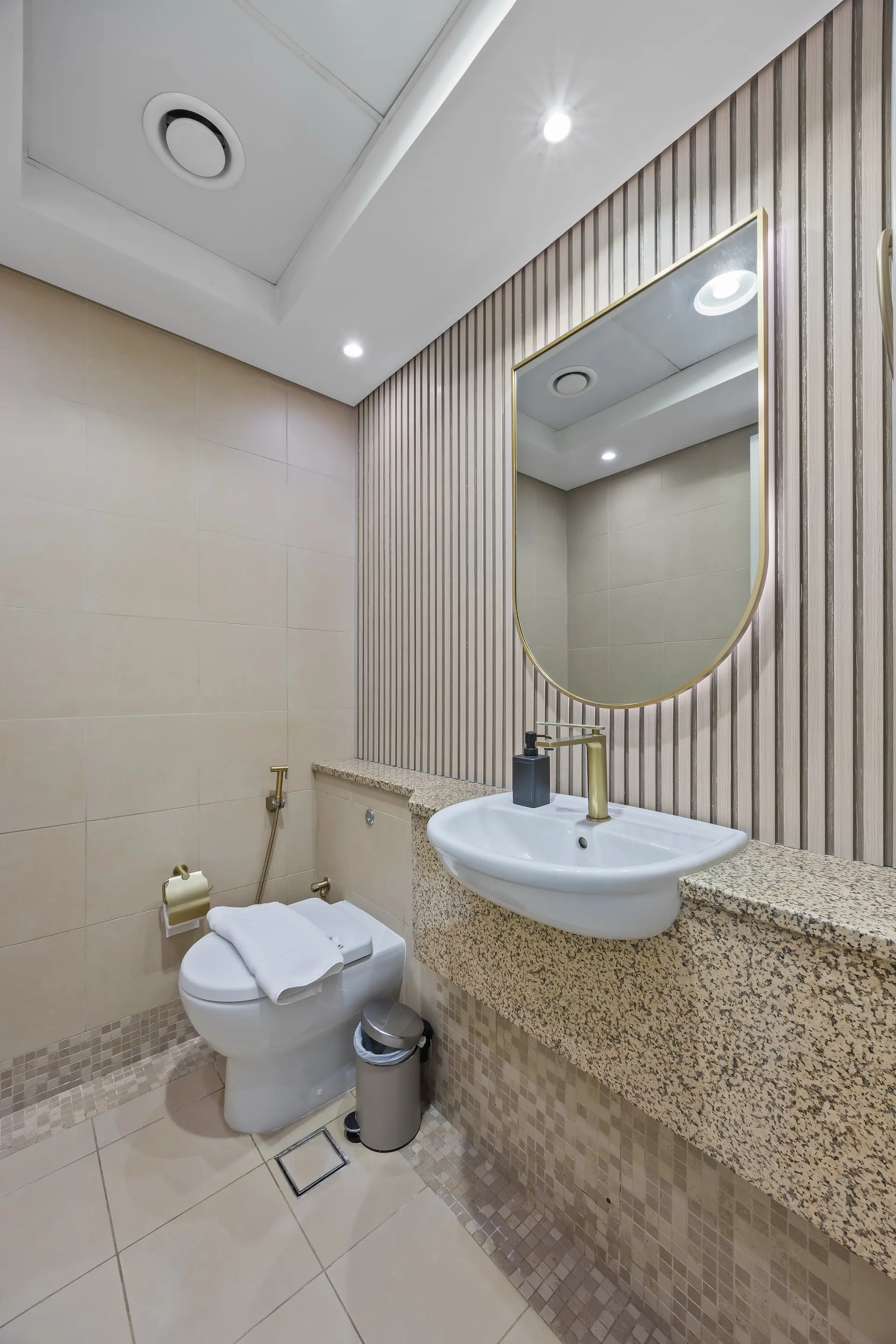 Guest powder room with gold-framed mirror at Sky Gardens DIFC Dubai