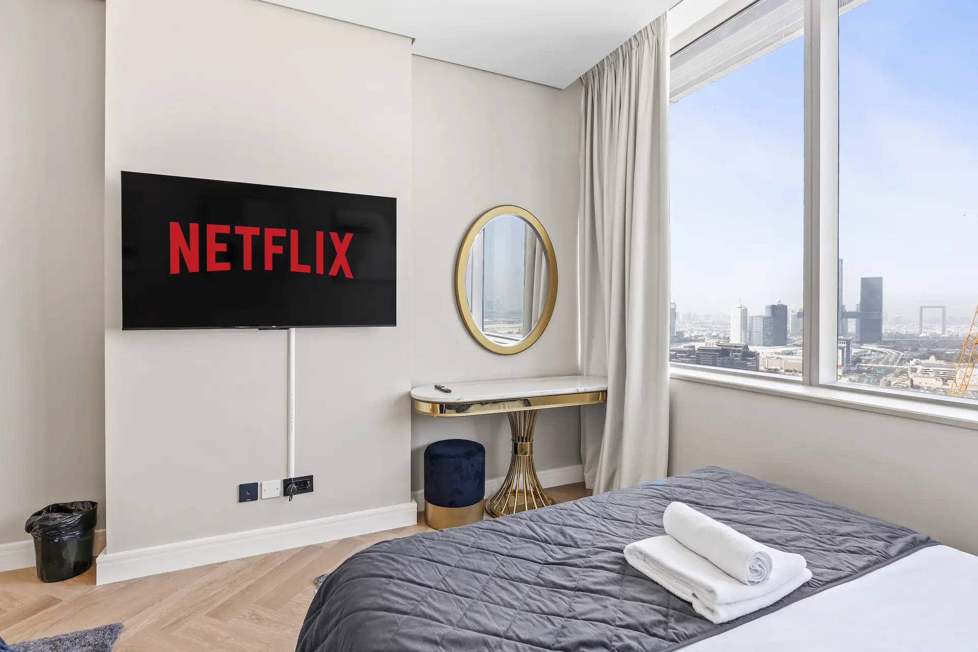Bedroom with smart TV, dressing table and city views at Sky Gardens DIFC Dubai