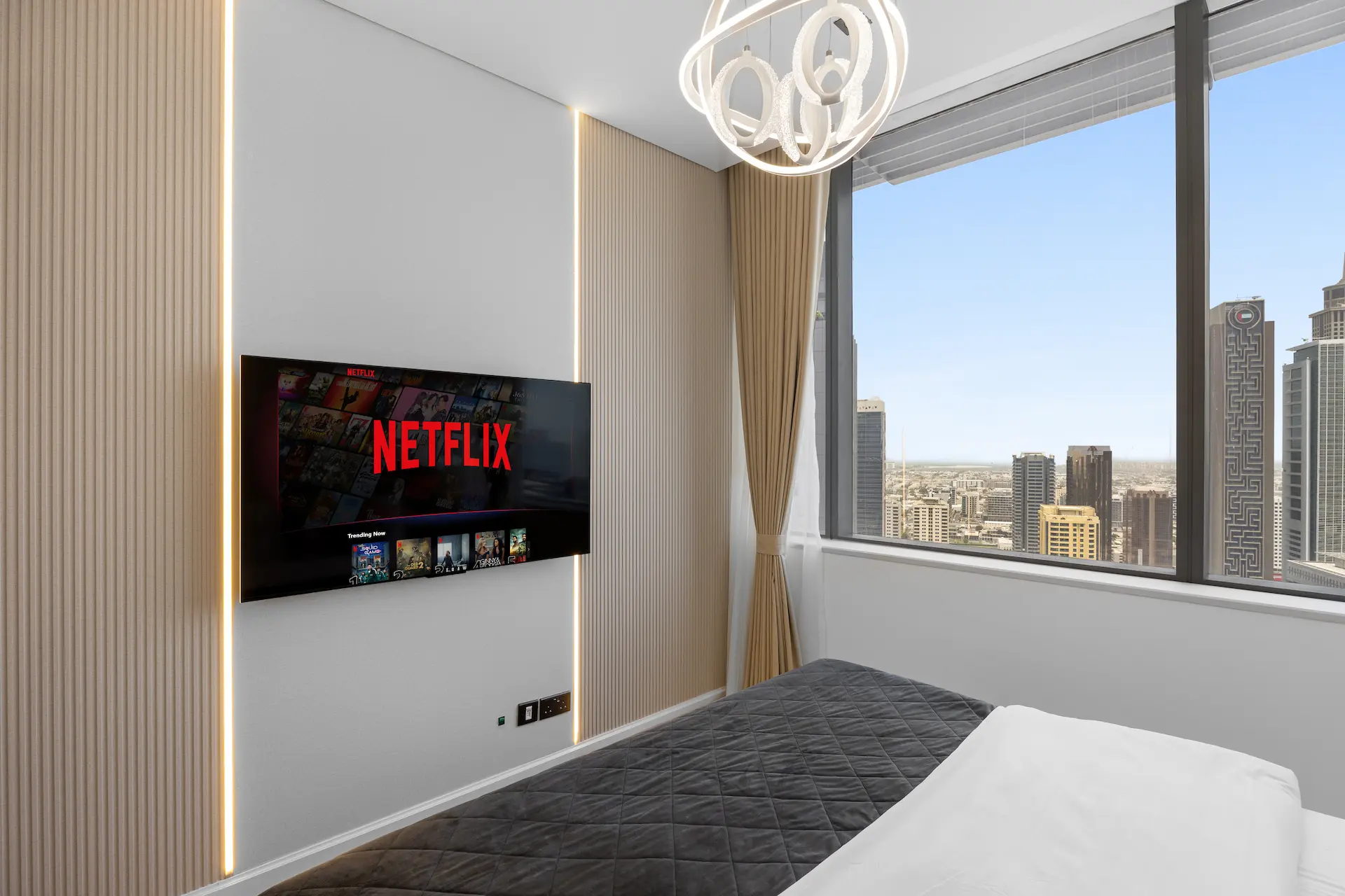 Bedroom smart TV wall with ambient lighting and DIFC city skyline view at Sky Gardens Dubai