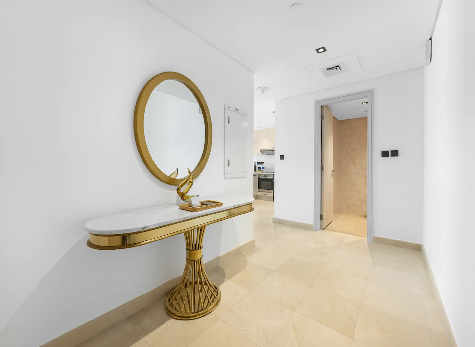 Entrance foyer with gold console table and oval mirror at Sky Gardens Business Class apartment DIFC Dubai