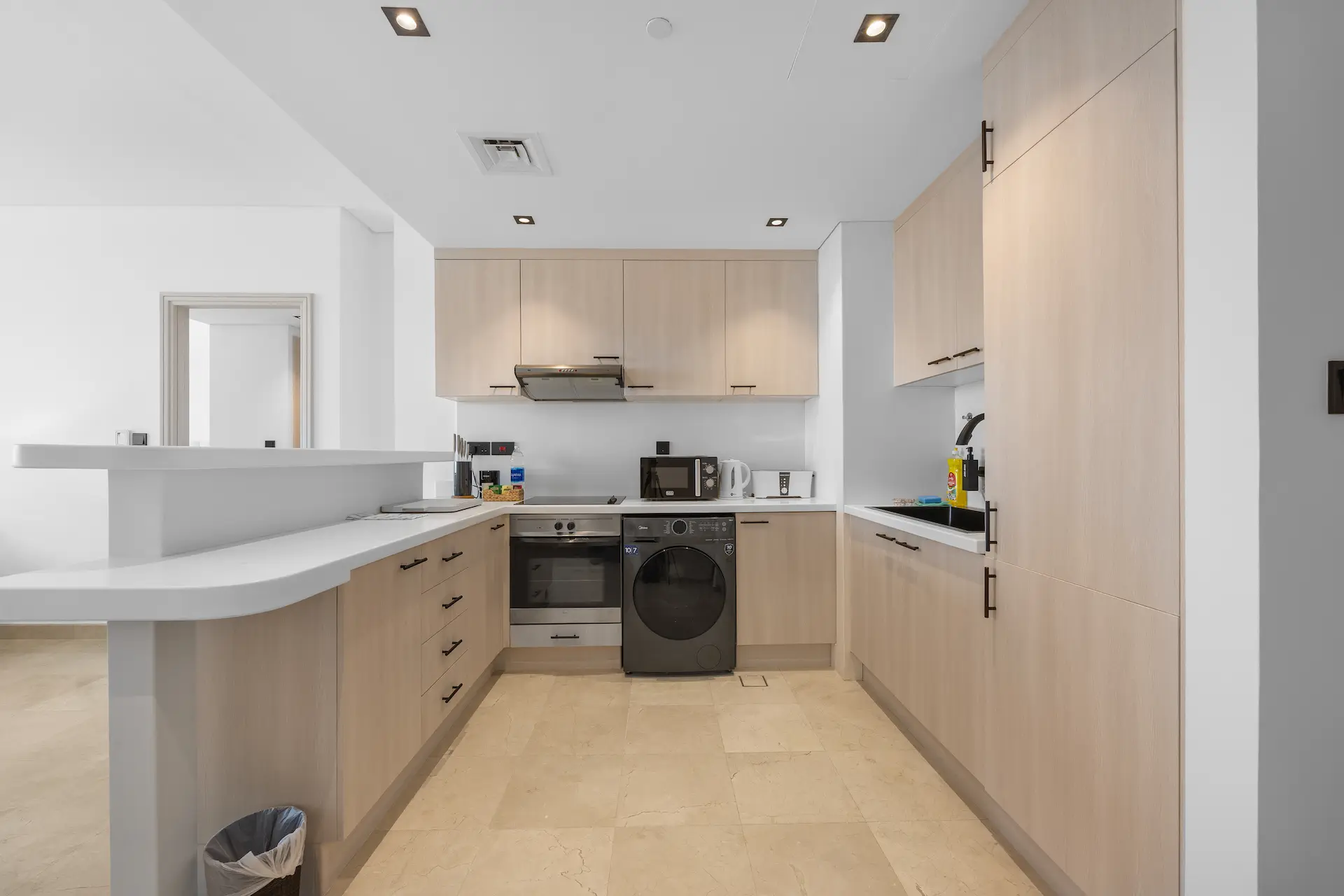 Fully equipped kitchen with oven, washer-dryer and full-height cabinetry at Sky Gardens DIFC Dubai