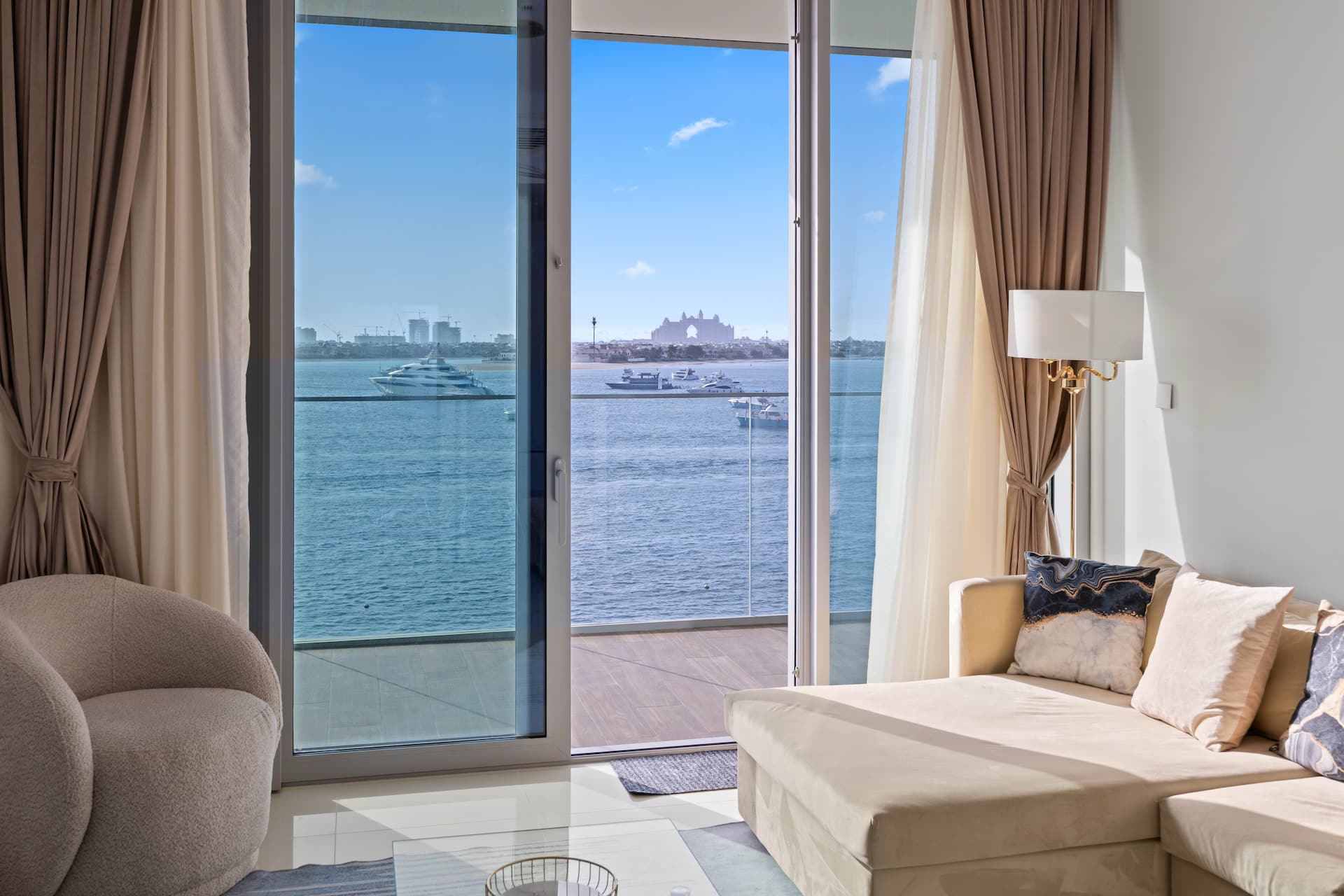 Living room with floor-to-ceiling windows and Palm Jumeirah views in luxury two bedroom apartment Emaar Beachfront Dubai