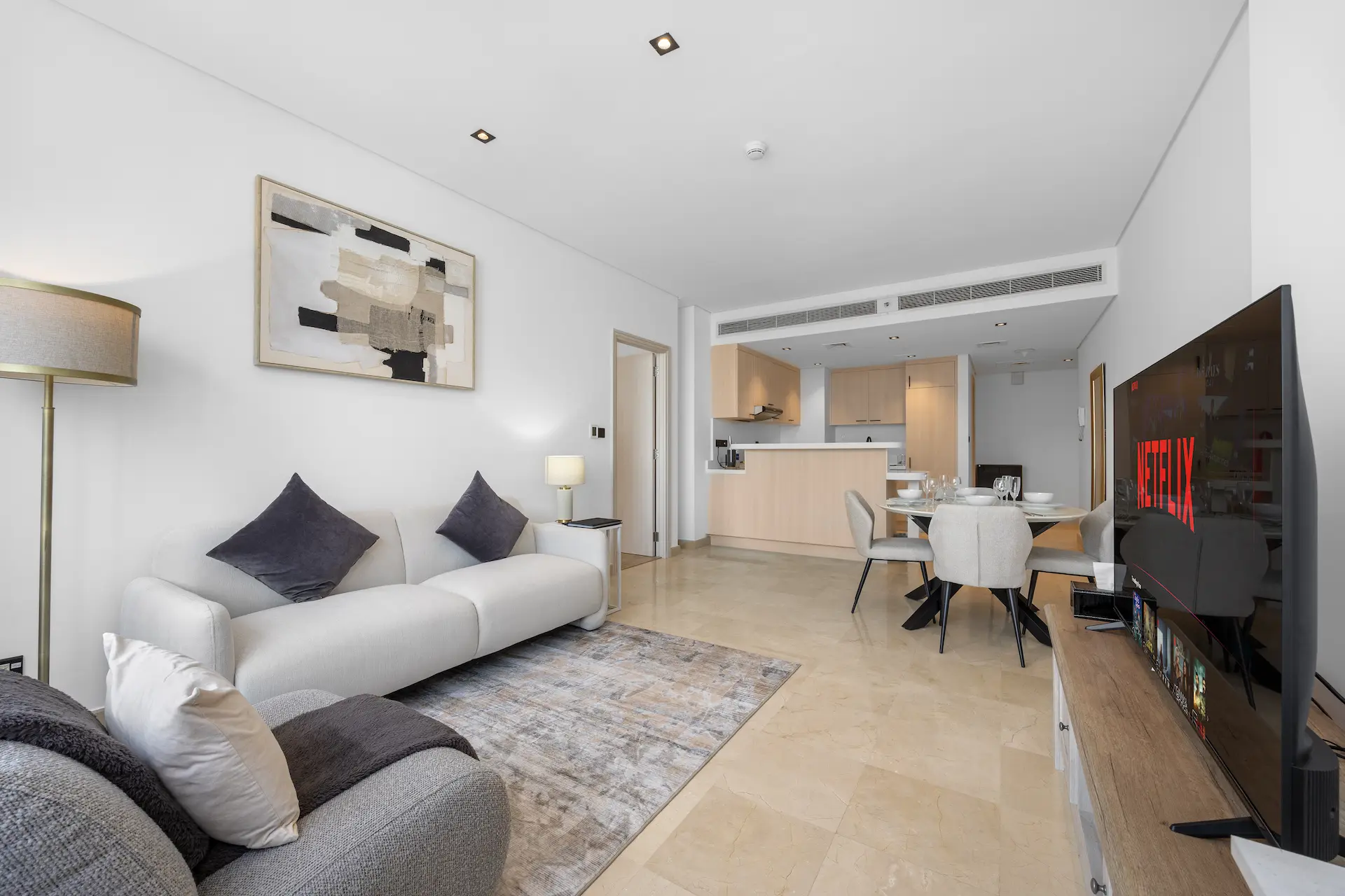 Bright open-plan lounge and kitchen with dining area at Sky Gardens Business Class apartment Dubai