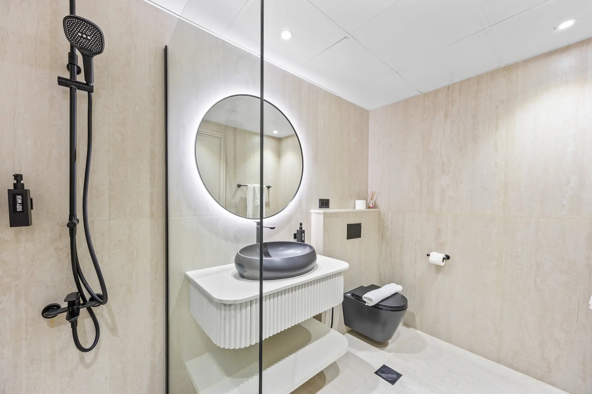 Designer bathroom with rainfall shower and black fixtures at Sky Gardens DIFC Dubai