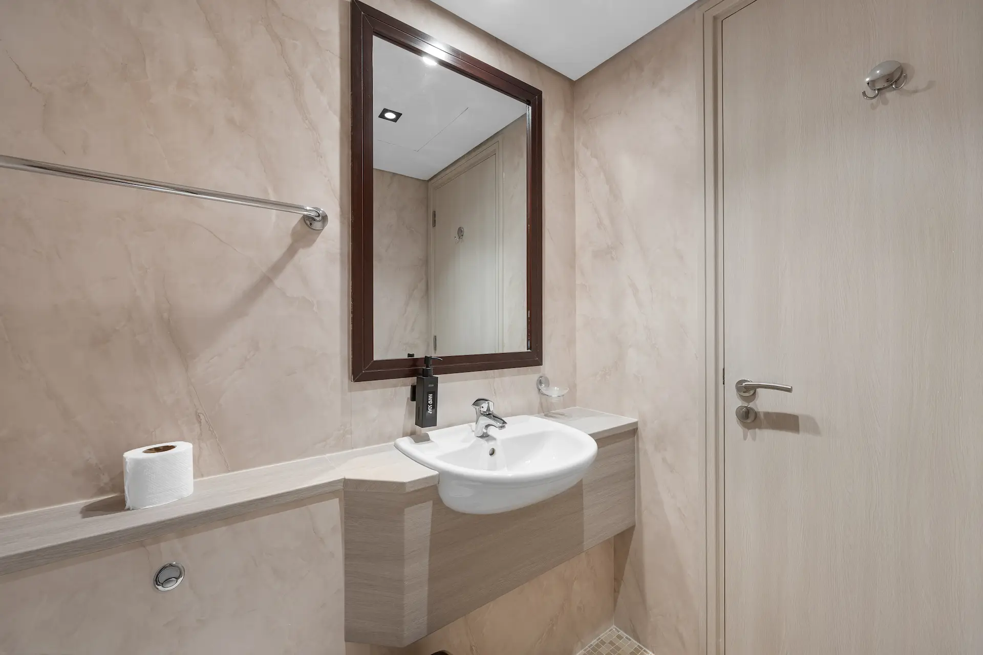 Second bathroom with marble walls and vanity mirror at Sky Gardens DIFC Dubai